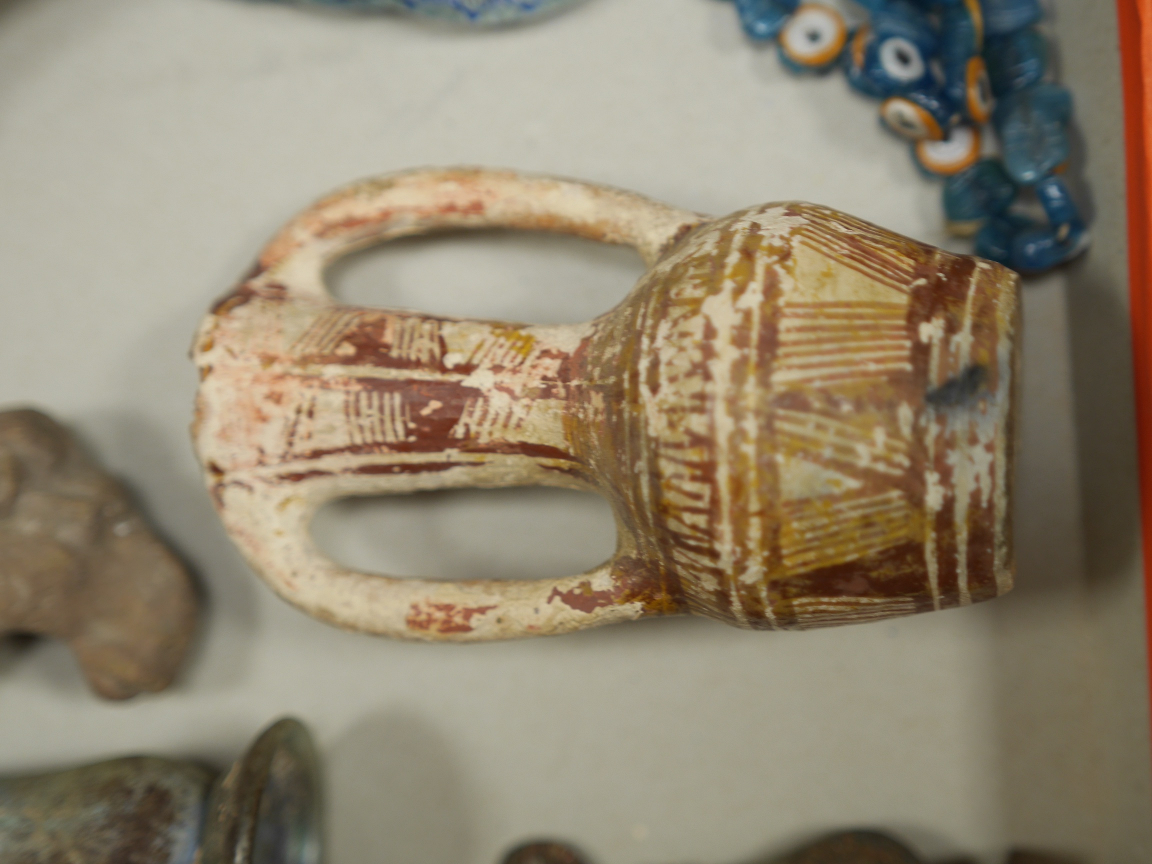 A collection of Roman, Ancient Greek and other items, including a glass vial, a broken glass bottle, a two handled pottery vase, shards of pottery items, a pottery figure head and other pottery items, an iron spear head,